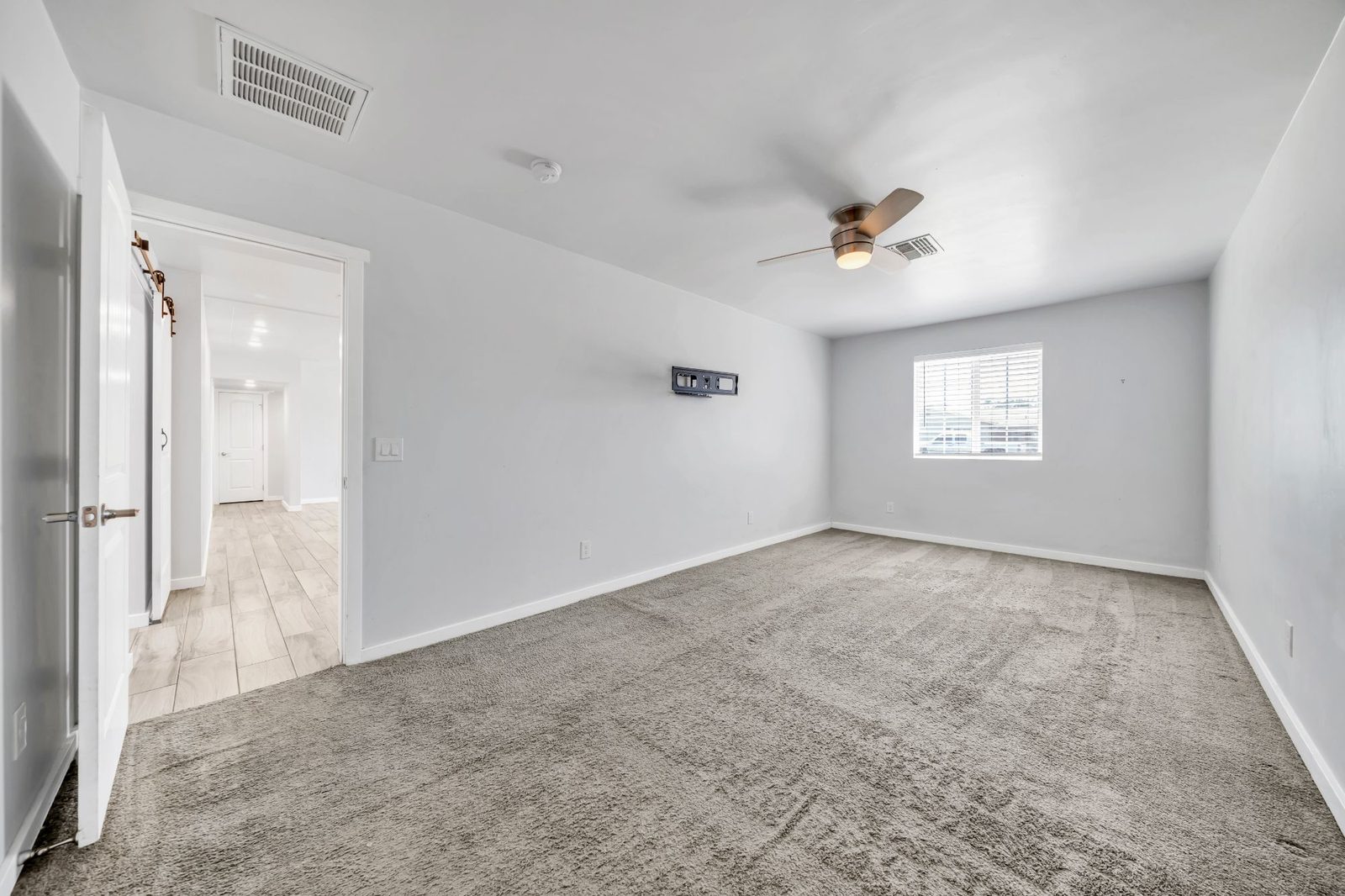 Second carpeted bedroom with a ceiling fan and a window