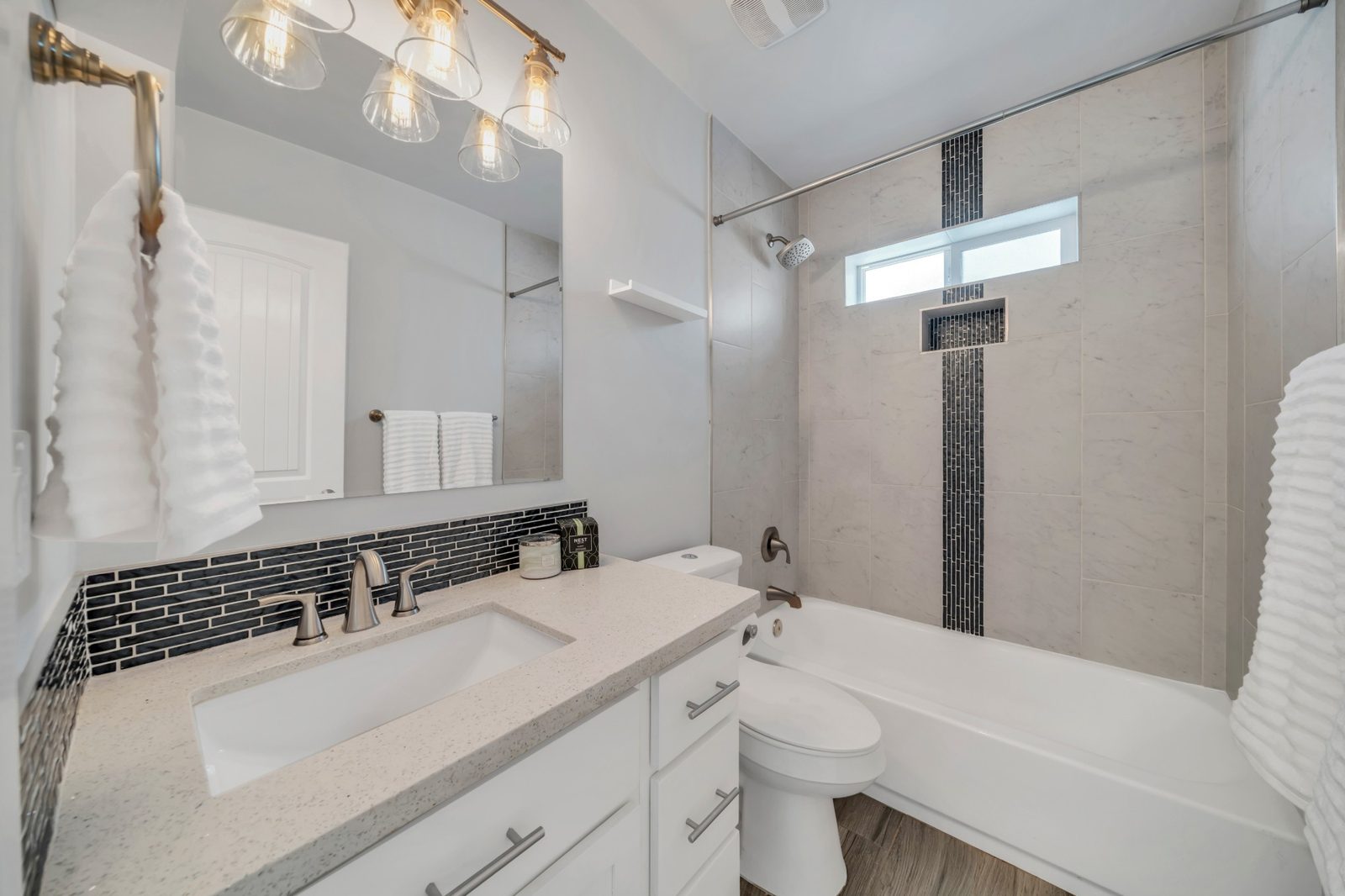 Second full bathroom with a quartz vanity and a tiled shower