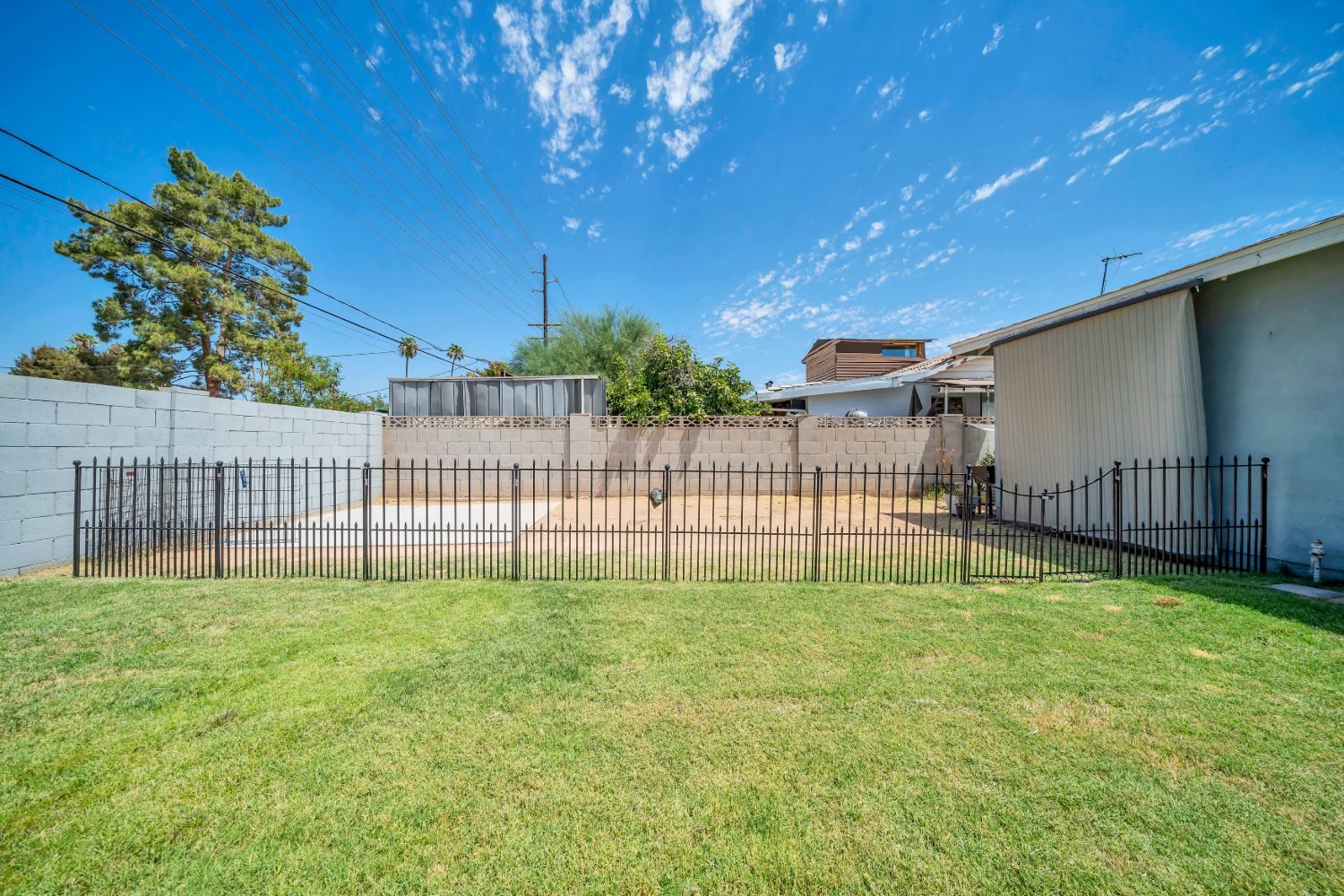 Rear lawn running to the block wall and wrought iron fencing